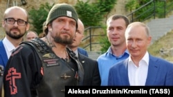 UKRAINE -- Leader of the Night Wolves Russian motorcycle club Aleksandr Zaldostanov (Surgeon) (L) and Russia's President Vladimir Putin (R) visit the 35th Coastal Defence Battery memorial centre in central Sevastopol, Crimea, August 18, 2017
