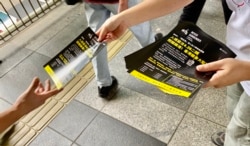 多个民间团体成员派传单，呼吁市民关注入境条例修订影响香港人出入境自由，形容是”闭关锁港” (美国之音/汤惠芸)