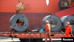 江苏省连云港的工人在向货轮上装运出口钢材。（2020年5月27日）