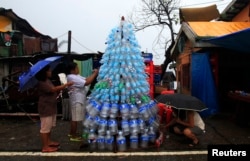 Victims of super Typhoon Haiyan decorate their improvised Christmas tree with empty cans and bottles at the ravaged town of Anibong, Tacloban city, central Philippines Dec. 24, 2013, a month after Typhoon Haiyan battered central Philippines.