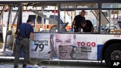Des policiers israéliens examinant le bus endommagé par une explosion à Tel Aviv