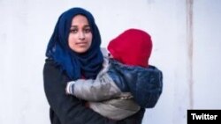 호다 무타나가 아들을 안고 있다.