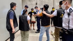 数十名警员包围准备游行的4名社民连成员及采访的记者，逐一搜查游行人士的背包、登记身分证资料，并有警员全程录影，面对一些4人游行，布防非常严密 （美国之音/汤惠芸)