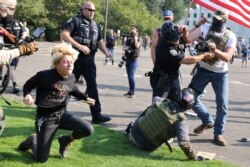 Polisi wakijaribu kudhibiti ghasia kati ya upande unaomuunga mkono Rais Donald Trump na waandamanaji wanaopaza sauti maisha ya mtu mweusi yanathamani nje ya jengo la Bunge la jimbo la Oregon huko Salem, Oregon, Marekani September 7, 2020.