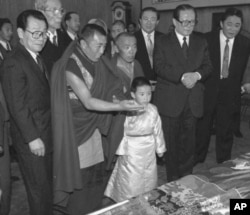 1996年1月12日，中方选择的六岁的11世班禅喇嘛向中国主席江泽民呈现给他的礼品。中国政协主席李瑞环在场。