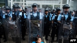 2019年6月12日，香港立法会外，一名抗议者坐在防暴警察面前。