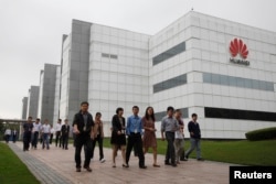 华为技术有限公司的员工走过广东省深圳市的公司办公楼（2012年4月17日）。