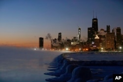 Ice forms along the shore of Lake Michigan before sunrise, Thursday, Jan. 31, 2019, in Chicago. (AP Photo/Kiichiro Sato)