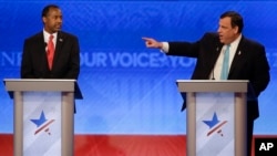 在美国广播公司主办的政见辩论会上，美国新泽西州州长克里斯.克里斯蒂手指联邦参议员鲁比奥，退休神经外科医生本·卡森看着克里斯蒂（2016年2月6日）