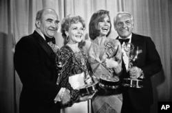 FILE - Members of "The Mary Tyler Moore Show" pose with their Emmys backstage at the 28th annual Emmy Awards in Los Angeles, May 18, 1976. From left are, Ed Asner, Betty White, Moore and Ted Knight.