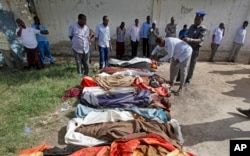 Somalis look at bodies of civilians displayed in the capital Mogadishu, Somalia, Aug. 25, 2017, following a botched joint U.S.-Somali raid.