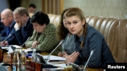 RUSSIA - Public figure Maria Butina (right) attends a meeting of a group of experts, affiliated with the government of Russia, in this undated handout photo obtained by Reuters on July 17, 2018