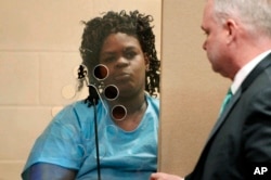 FILE - Latarsha Sanders, 43, is arraigned in Brockton, Mass., District Court on two counts of murder, standing with her defense attorney Joseph Krowski, Jr., Feb. 6, 2018.