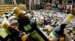 Petugas memusnahkan botol miras yang disita dari toko-toko pinggir jalan di Jakarta 29 Agustus 2008. (Foto: REUTERS/Supri)