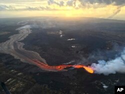 In this July 17, 2018 photo provided by the U.S. Geological Survey, sunrise is seen over the Kilauea volcano lower East Rift Zone in Hawaii.