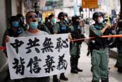 一名香港抗议者在主权回归纪念日举行的抗议港版国安法游行中举牌指责中共背信弃义。（2020年7月1日）