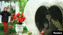 A girl walks passed a grave April 6, 2002, where a couple were buried together after being killed in no-man's land in wartime Sarajevo between Bosnian government and Serb positions in 1993. The family made a joint heart-shaped tombstone for Admira Ismic, a Muslim, and her Serb boyfriend Bosko Brkic, who became known as Sarajevo's Romeo and Juliet when they were killed trying to escape from the 1992-5 siege by Bosnian Serb forces. Bosnia marks the 10th anniversary of the outbreak of war on Saturday, a 43-month-long conflict that was Europe's worst since World War Two.