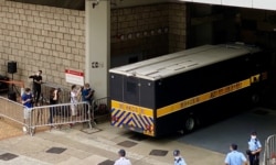 有声援唐英杰的市民质疑当局安排多部囚车出入高等法院，企图误导支持者，不能送别押解唐英杰到监狱的囚车（美国之音/汤惠芸）