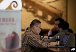 FILE - In this Feb. 16, 2015 file photo, a man surfs Internet on his laptop computer at a Starbuck cafe in Beijing. Chinese President Xi Jinping called Wednesday, Dec. 16 for governments to cooperate in regulating Internet use.