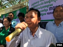 លោក ហេង ជឿន ប្រធានសហព័ន្ធសហជីពកម្មករវិស័យកសិកម្ម ថ្លែងទៅកាន់អ្នកសារព័ត៌មាន ក្នុងពេលប្រមូលផ្តុំដាក់ញត្តិសុំកំណត់ប្រាក់ខែគោលនៅក្រសួងការងារ រាជធានីភ្នំពេញ ថ្ងៃទី១៥ ខែកក្កដា ឆ្នាំ២០១៩។ (កាន់ វិច្ឆិកា/VOA)