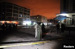 Policemen inspect the secured section at the scene of the blast in Eastleigh suburb of Kenya's capital Nairobi, December 7, 2012.