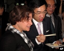 江启臣与何玺梦尝试台湾小吃