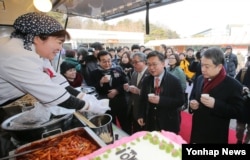 지난 1월 경기도 과천시 서울경마공원에서 열린 탈북민 푸드트럭 개업식에서 정진행 현대자동차그룹 사장(오른쪽부터), 홍용표 통일부 장관, 손광주 남북하나재단 이사장, 현명관 한국마사회장 등 참석자들이 탈북민 김경빈 씨의 음식을 맛보고 있다.