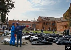 袭击过后，紧急救援人员将遇难者尸体移至学校外空地暂时停放