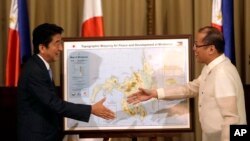PM Jepang Shinzo Abe (kiri) dan Presiden Filipina Benigno Aquino berjabat tangan dalam pertemuan di Manila, Filipina (27/7). 