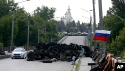 5月13日一辆轿车通过乌克兰东部一个悬挂俄罗斯国旗的路障