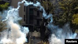 Anti-government protesters walk through tear gas during riots in Caracas, Apr. 6, 2014. 