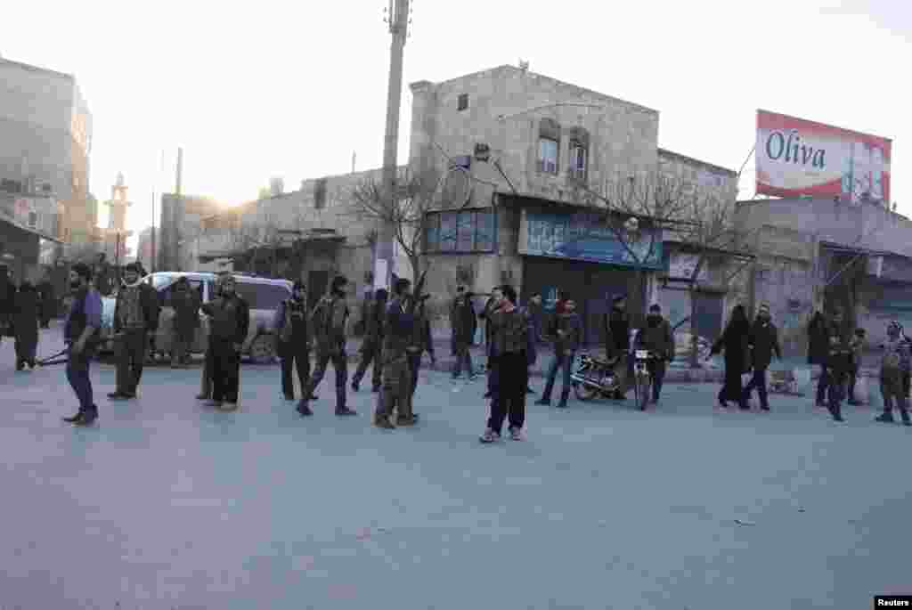 시리아 알레포에서 7일 반군과 알카에다 연계 이슬람무장단체의 교전이 벌어진 가운데 반군 병사들이 무기를 들고 이동하고 있다.