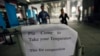 A sign requesting people to come have their temperature taken is seen at the entrance to the Canton Fair in Guangzhou, Guangdong province, Oct. 26, 2014.