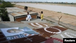 Penduduk Kamboja di sekitar bandara Phnom Penh memasang foto Presiden Amerika Barack Obama di atap rumah mereka dan menuliskan "SOS" sebagai permintaan dukungan agar tidak diusir dari rumah mereka (14/11). Sedikitnya delapan orang ditangkap karena aksi protes menjelang kunjungan Presiden Obama ke negara ini pekan depan.