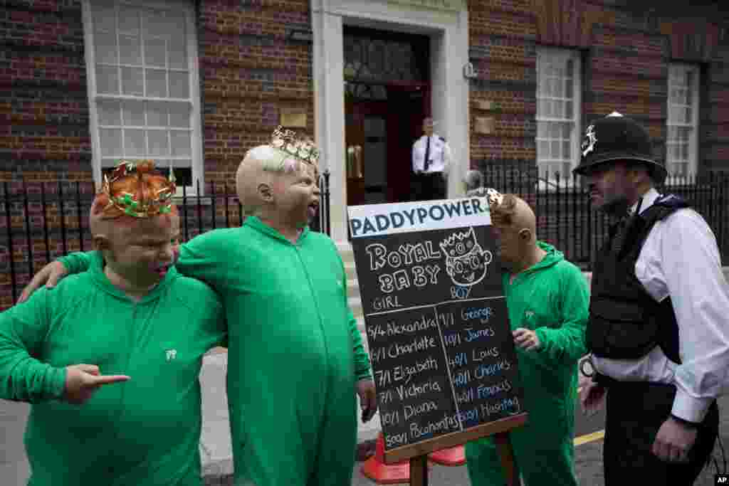 Wakil-wakil dari sebuah perusahaan taruhan memakai topeng bayi dan melakukan aksi publisitas di luar Rumah Sakit St. Mary&#39;s di London, tempat Catherine, Duchess of Cambridge diperkirakan akan melahirkan. (AP/Matt Dunham)