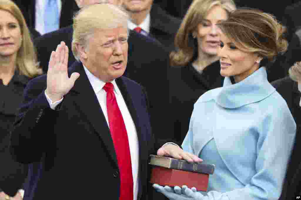 Le président élu Donald J. Trump prête serment en tant que 45e président des États-Unis , alors que sa femme Melania tient la Bible à Washington, le 20 janvier 2017.