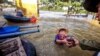 A boy gets food donation from a volunteer at a flooded area in Quang Binh province, Vietnam, Oct. 22, 2020. (Reuters)