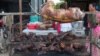 Grilled dog meat are on display at a food kiosk along a street in Phnom Penh. (Neou Vannarin/VOA Khmer) 
