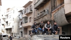 Tentara Pembebasan Suriah berpose di atas sebuah tank yang mereka sita dari rejim Suriah di Homas, awal April 2013. Kota ini kembali dikuasai oleh Pasukan Pemerintah Suriah, Kamis (2/5).