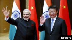 Perdana Menteri India Narendra Modi (kiri) dan Presiden China Xi Jinping melambaikan tangan kepada wartawan sebelum mengadakan pembicaraan di Xian, provinsi Shaanxi, China (14/5). (Reuters/Kim Kyung-Hoon)