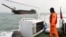 A Taiwanese coast guard looks at a sand-dredging ship with Chinese flag in the waters off the Taiwan-controlled Matsu islands, January 28, 2021. (REUTERS/Ann Wang)