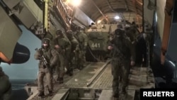 سربازان روسیه در حال پیاده‌شدن از یک هواپیمای نظامی در یک فرودگاه نظامی در قزاقستان. ٨ ژانویه ٢٠٢٢