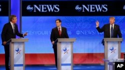 Kandidat capres Partai Republik Jeb Bush, kiri, dan Donald Trump, kanan, berdebat sementara Marco Rubio, tengah, mendengarkan pada debat kandidat capres Partai Republik di St. Anselm College, 6 Februari 2016, di Manchester, N.H.