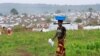 FILE - A Congolese woman, who fled ethnic fighting in the Democratic Republic of Congo on a fishing boat, across Lake Albert, carries belongings on her head at a UNHCR settlement camp in Kyangwali, Uganda, March 20, 2018.