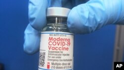 A vial of Moderna COVID-19 vaccine is held at a vaccination site Friday, Feb. 19, 2021, in Oklahoma City. (AP Photo/Sue Ogrocki)