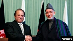 President Afghanistan Hamid Karzai (kanan) berjabat tangan dengan PM Pakistan Nawaz Sharif seusai konferensi pers bersama di Kabul (30/11).