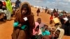 FILE - In this Friday Aug. 5, 2011 file photo, Somali refugees walk through an area housing new arrivals, on the outskirts of Hagadera Camp outside Dadaab, Kenya. 