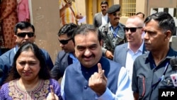 Gautam Adani, kepala konglomerat India Adani Group dan istrinya Priti Adani menunjukkan jari bertinta usai menjalankan hak pilih di Ahbedabad, 7 Mei 2024. (Foto: Sam Panthaky/AFP)