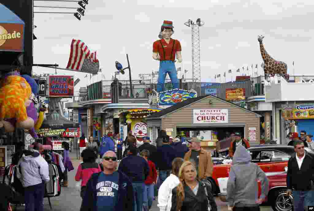 Para warga berjalan di atas jembatan setahun setelah hancur oleh Badai Super Sandy, Seaside Heights, New Jersey. (AP/Mel Evans)
