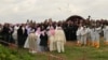Yazidi priests release doves into the air after blessing a mass grave while the exhumation team stands by to begin their work in Kocho, Iraq, March 15, 2019. 